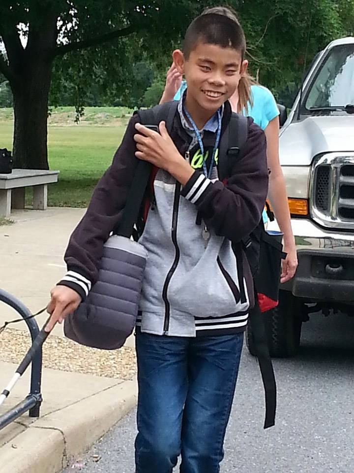 Michael walking to school with can in hand and tech in his backbpack
